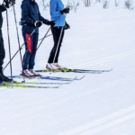 three people on skis awaiting instruction